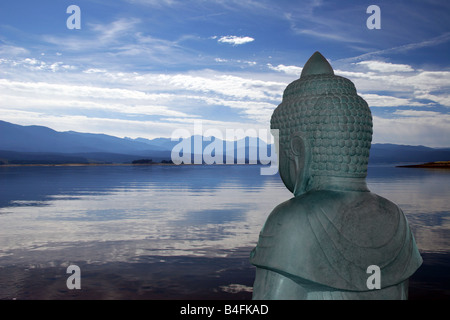 Stein Buddha vor einem entspannenden Bergsee Stockfoto