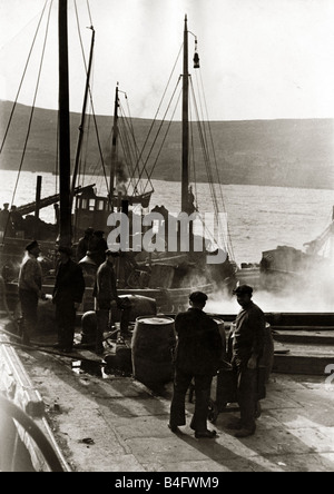 Shetland-Fischer ihren Fang nach einem Tag beim Angeln Industrie Fischerboote Trawler Masten Riemenscheiben Fässer Juli 1935 bringen Stockfoto