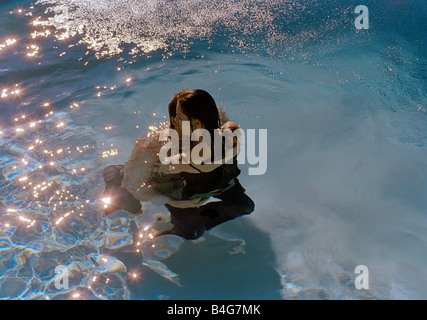 Ein junges Paar in einem Schwimmbad umarmen Stockfoto
