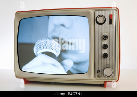 Ein Fernseher mit einem schwarz / weiß Bild einer Person in ein Mikrofon singen Stockfoto