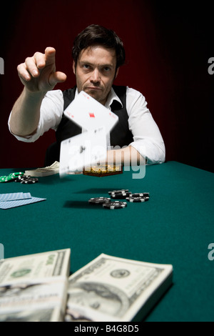 Ein Mann wirft zwei Ace Karten bei einem high-Stakes Pokerspiel Stockfoto