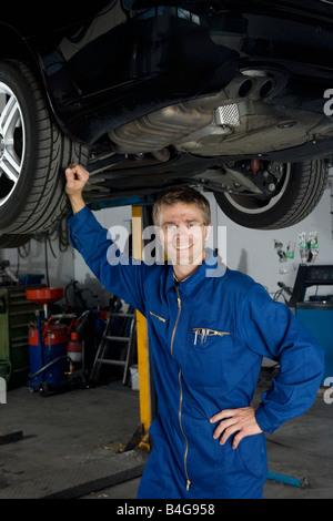 Ein Auto Mechaniker steht unter einem Auto Stockfoto