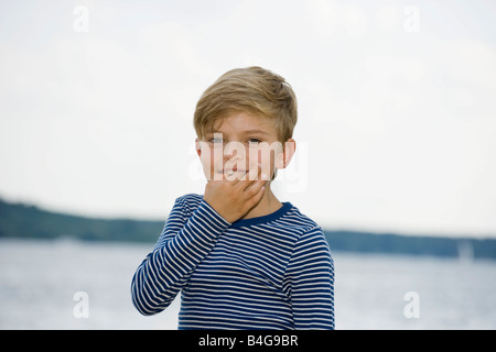 Ein kleiner Junge mit seinen Fingern Pfeifen Stockfoto