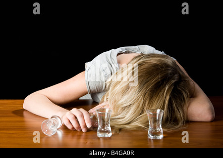 Eine junge Frau ohnmächtig betrunken in einer Bar Theke Stockfoto