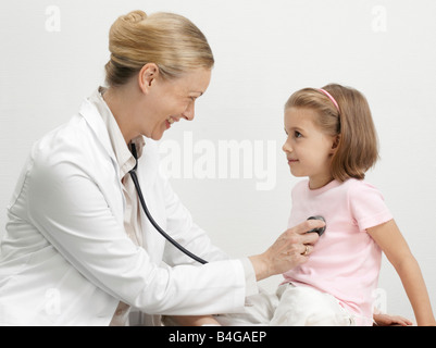 Eine weibliche Kinderarzt setzen ein Stethoskop auf das Herz eines jungen Mädchens Stockfoto