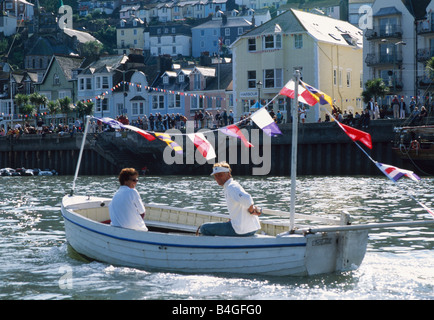 Paar in kleinen Holzboot mit bunten Girlanden im Hafen von Dartmouth Stockfoto