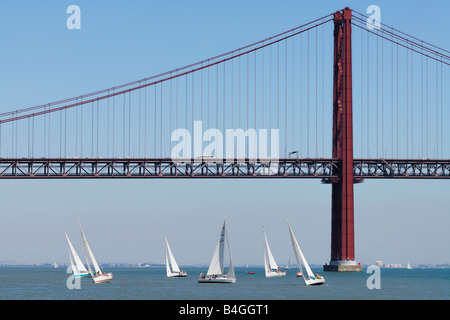 Lissabon Portugal Yachten Segeln auf den Tejo mit der Ponte 25 de Abril im Hintergrund Stockfoto