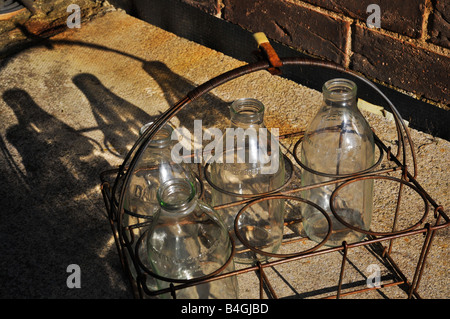 Vier leere Glas-Milchflaschen warten auf die Milch-Mann, vorbei Stockfoto