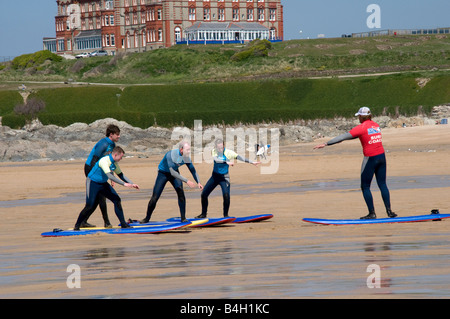 Gruppe von Freunden in Surfschule erhalten Anweisungen von einem Instruktor auf fistral Strand Newquay Cornwall Stockfoto