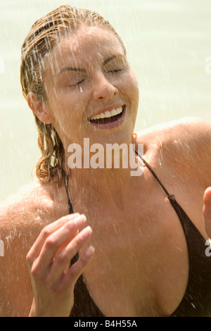 Nahaufnahme von Frau unter Dusche und lächelnd Stockfoto