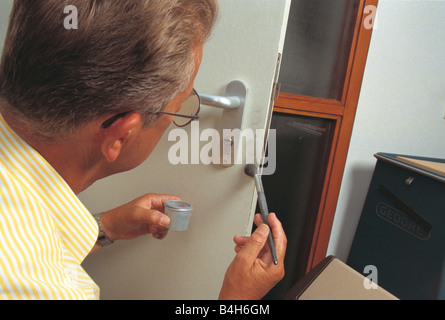 Nahaufnahme der Polizist Anwendung Fingerabdrücke auszusetzen Flüssigkeiten auf Tür, Niederlande Stockfoto