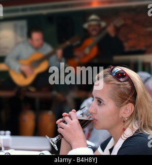 Mädchen trinken Bier allein in einem Restaurant mit live-Musik Stockfoto