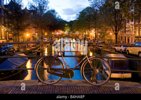 Fahrrad, stützte sich auf Geländer auf der Brücke über den Kanal, Keizersgracht, Amsterdam, Niederlande Stockfoto