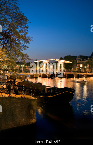 Zugbrücke über Fluss beleuchtet in der Nacht, Magere Brug, Fluss Amstel, Amsterdam, Niederlande Stockfoto