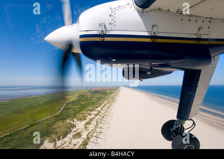 Propeller-Flugzeug fliegt über Strand Stockfoto
