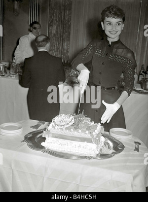 Audrey Hepburn kann 1953 Film Schauspielerin Einschnitte in ihre willkommen zu Hause Kuchen Stockfoto
