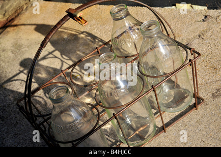 Vier leere Glasflaschen Milch warten darauf, durch volle ersetzt werden. Warten auf die Milch-Mann... Stockfoto