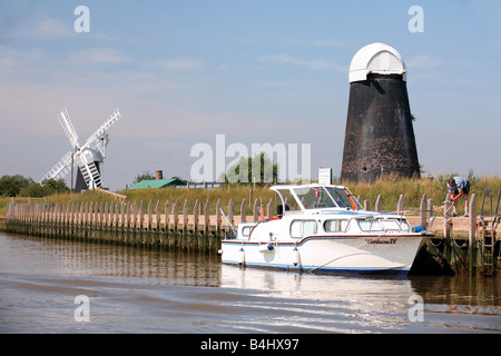 Ein Mann, der sein Boot am Polkey s Mühle auf der linken Seite mit den Reedham Marshes-Segeln auf den Norfolk Broads festmachen Stockfoto