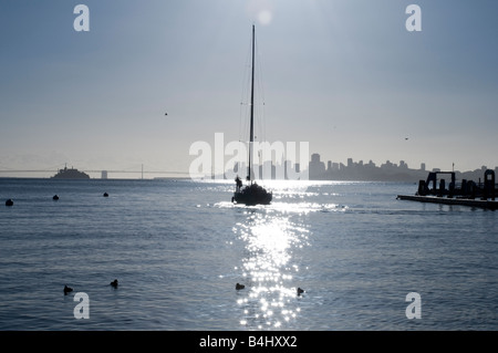 Silhouette einer Yacht als es, Sausalito, Kalifornien mit San Fransisco Skyline am Horizont verlässt Stockfoto