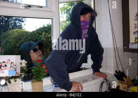 Teenager brechen kletternd durch ein Fenster in ein Haus Stockfoto