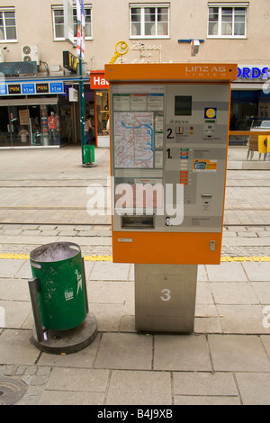 Ein Fahrkartenautomat für öffentliche Verkehrsmittel in Linz mit Stadtplan und Mülleimer daneben. Stockfoto