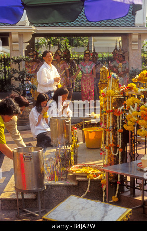 Die Gläubigen im Gebet am Erawan-schrein, Bangkok, Thailand. Klassische Thai Tänzer hinter sich. Stockfoto