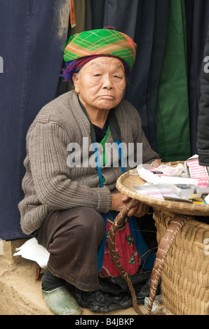Ein Portriat einer älteren Flower Hmong-Frau sitzt an ihrem Stand in Bac Ha Markt Vietnam Stockfoto