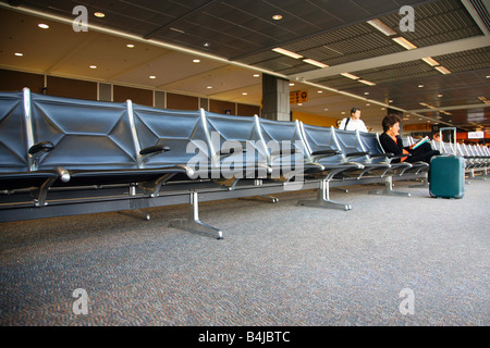 Frau liest in einem meist leeren Flughafen-Gate, Austin-Bergstrom International Airport Stockfoto