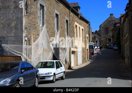 D7. Straße in St. Suliac mit Fischerhäuschen mit Fischernetzen, die draußen hängen. St. Suliac ist ein Fischerdorf am Rance River Stockfoto