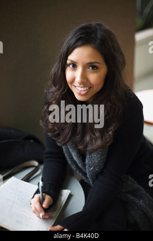 Orientalische Frau schreiben in notebook Stockfoto