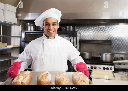 Hispanische männlichen Baker, die holding Tablett mit frischen Brötchen Stockfoto