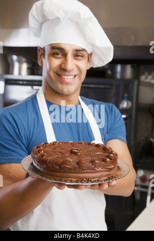 Hispanische männlichen Konditor Kuchen halten Stockfoto