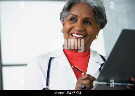 Afrikanische Ärztin schreiben in medizinischen Diagramm Stockfoto