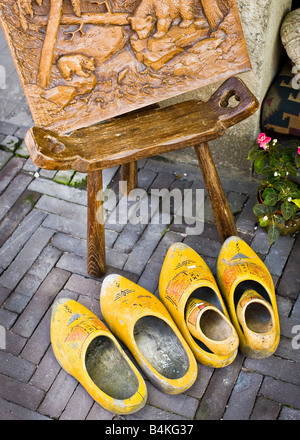 Abgenutzte holländische Holzschuhe und ein hölzernes Schnitzen vor einem Geschäft in den Haag, Niederlande Stockfoto