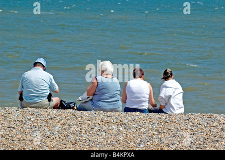 Familie sitzt auf Kies Strand Aldeburgh Suffolk England UK Stockfoto