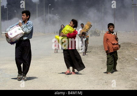 Irak-Krieg 2003 einheimischen fliehen die brennende Stadt Basra im Südirak, wie gepanzerte Bestandteil der Royal Scots Dragoon Guards der nach außen Röcke der Stadt erreichen Stockfoto