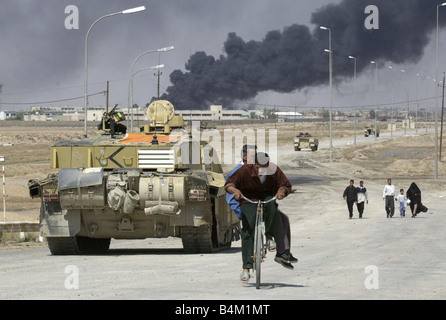 Irak-Krieg 2003 einheimischen fliehen die brennende Stadt Basra im Südirak, wie gepanzerte Bestandteil der Royal Scots Dragoon Guards der nach außen Röcke der Stadt erreichen Stockfoto