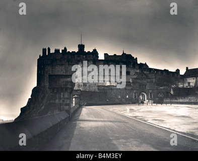 Das Licht von der Princes Street bildet einen Heiligenschein um Edinburgh Castle, wie Dämmerung auf die schottische Hauptstadt Wahrzeichen Schottland Nacht Szene militärische Circa 1935 Mirrorpix fällt Stockfoto