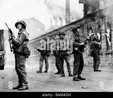 Britische Truppen bewachen im Belfast Straße fällt während der Ausschreitungen als ein Gebäude in Brand gesteckt auf dem Höhepunkt der Riot Verbrennungen August 1969 Stockfoto