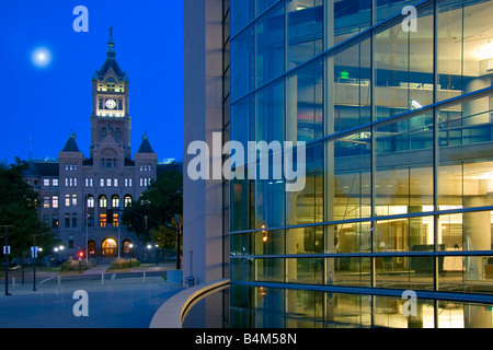 Vollmond über der imposanten Fassade des Salt Lake City und County Building gegenübergestellt gegen die moderne Hauptbibliothek Stockfoto