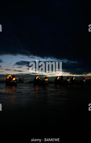 Auf der Themse durch die Thames Barrier in Woolwich, Canary Wharf in weiter Ferne, London anzeigen Stockfoto