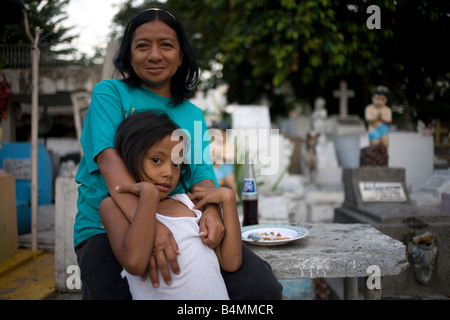 Eine Filipina und ihre Tochter sitzen außerhalb der eigenen Wohnung auf dem Stadtfriedhof von Makati in Makati City (Metro Manila), Philippinen. Stockfoto