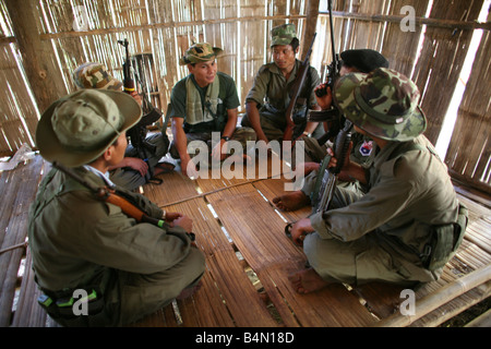 Straflosigkeit Soldaten sitzen in einer Gruppe in einer Hütte In Myanmar Birma Tausende von Menschen siedelten sich in der Nähe von der Grenze als Folge der Unterdrückung in ihrem Heimatland um 200 birmanischen Vertriebenen, in La niedergelassen haben pro Her ein Dorf auf der burmesische Seite der Grenze zu Thailand in der Nähe der thailändischen Stadt von Mae Sot sie weigern sich, die Grenze zu überqueren, weil sie in ihrer Heimat dieser Flüchtlinge bleiben wollen unterstützen die Rebellenbewegung namens Straflosigkeit Karen Nationale Befreiung-Armee betreibt in östlichen Birma Jan 2007 Stockfoto