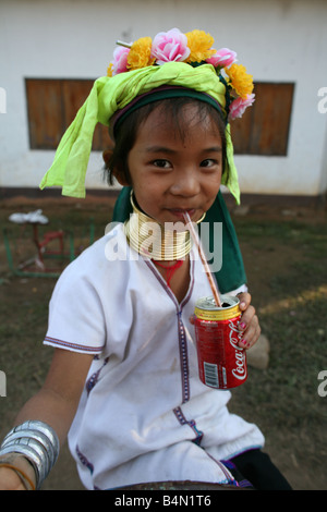 Ein Mädchen Longneck trinkt eine Cola ca. 300 birmanischen Flüchtlinge in Thailand sind Mitglieder der indigenen Gruppe bekannt als die Longnecks, die größte der drei Dörfer wo live Longnecks Nai Soi genannt befindet sich in der Nähe von Mae Hong Son Stadt longnecks, tragen Metallringe auf den Hals, die das Schlüsselbein nach unten drücken und verlängern dem Hals, sie sind, ein Tourist Anziehung Touristen besuchen Nai Soi zu fotografieren die Longnecks und kaufen ihr Kunsthandwerk der Dörfer werden von Menschenrechtsorganisationen als menschliche Zoos kritisiert. Stockfoto