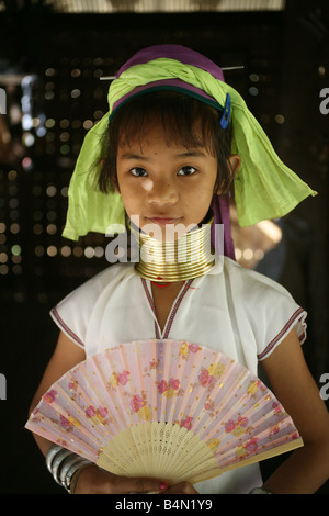 Porträt eines Mädchens mit einem Ventilator ca. 300 birmanischen Flüchtlinge in Thailand Mitglieder der indigenen Gruppe bekannt sind als die Longnecks, die größte der drei Dörfer wo live Longnecks Nai Soi genannt befindet sich in der Nähe von Mae Hong Son Stadt longnecks, tragen Metallringe auf den Hals, die das Schlüsselbein nach unten drücken und verlängern dem Hals, sie sind, eine touristische Attraktion Longneck Touristen besuchen Nai Soi zu fotografieren die Longnecks und ihr Kunsthandwerk kaufen Die Dörfer sind als menschliche Zoos von Menschenrechtsorganisationen kritisiert. Stockfoto