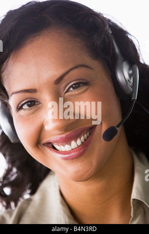 Geschäftsfrau tragen Kopfhörer im Büro lächelnd (hohe Schlüssel/selektiven Fokus) Stockfoto