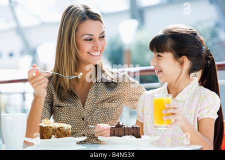 Mutter im Restaurant mit Tochter Essen Dessert und lächelnd (Tiefenschärfe) Stockfoto