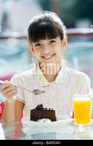 Junges Mädchen im Restaurant Essen Dessert und lächelnd (Tiefenschärfe) Stockfoto