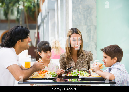 Familie im Restaurant Essen und lächelnd (Tiefenschärfe) Stockfoto