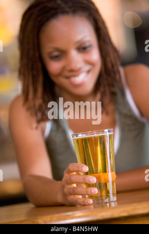 Frau, die ein Glas Bier Stockfoto